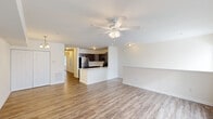 Located at 2411 Tinas Way in Seaford, Delaware, this well-appointed 2-bedroom, 2-bathroom single-story home offers a thoughtfully designed open-concept layout. The combined living and kitchen area forms the heart of the home, featuring durable wood-look flooring and a ceiling fan with integrated lighting. Large windows dressed with horizontal blinds invite abundant natural light, creating a bright and welcoming atmosphere throughout.

The kitchen is a standout feature, equipped with stainless steel appliances including a refrigerator, range, and over-the-range microwave. Rich, dark-toned cabinetry contrasts beautifully with light countertops and a peninsula that provides additional prep space and casual seating. A stainless steel undermount sink adds a clean, functional touch.

Both bedrooms are carpeted for comfort and include ceiling fans and closets. The spacious primary bedroom offers generous room for furnishings. A secondary bedroom features windows that bring in natural light. Both bathrooms are finished with wood-look tile flooring, dark vanity cabinetry, and full tub-shower combinations with clean white surrounds. The overall aesthetic of the home is clean, neutral, and move-in ready.
