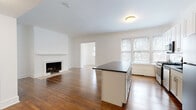 Located at 3030 N Sheridan Road in Chicago's sought-after Lakeview neighborhood, this single-floor residence combines classic architectural charm with modern updates throughout. Rich hardwood floors flow seamlessly across the open living and dining areas, reflecting natural light that pours in through multiple windows fitted with blinds. The living room is anchored by a wood-burning fireplace with a clean white surround, adding warmth and character to the space. Crown molding and crisp white walls contribute to a timeless, polished aesthetic. The kitchen is thoughtfully designed with white shaker-style cabinetry, dark stone countertops, a subway tile backsplash, and a full suite of stainless steel appliances including a gas range, dishwasher, microwave, and refrigerator. A peninsula island provides additional prep and seating space. The bedroom is generously sized, featuring a ceiling fan, hardwood floors, and direct access to a private bathroom. The bathroom is finished with large-format white tile flooring, a modern vanity with brushed nickel fixtures, and a window for natural ventilation. A dedicated closet space and entry area complete the functional layout, making this a well-rounded residence in a prime Chicago location.