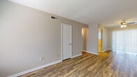This single-floor 1-bedroom, 1-bathroom residence offers a practical and comfortable layout designed for easy living. The main living area welcomes you through a classic six-panel front door and is finished with durable wood-look plank flooring in a warm, natural tone. Neutral taupe walls throughout create a clean, cohesive aesthetic. A ceiling fan with integrated lighting provides both comfort and illumination, while large vertical blinds along the sliding access door allow for adjustable natural light. HVAC vents are conveniently positioned throughout the living space for year-round comfort.

The kitchen is efficiently arranged in a U-shaped configuration, featuring white cabinetry with ample upper and lower storage, dark granite-style countertops, and light tile flooring. A double-basin stainless steel sink sits beneath a window that invites natural light, and the kitchen is equipped with a white refrigerator, electric range, and dishwasher.

The bedroom is carpeted for comfort and includes a ceiling fan with lighting and a window with blinds that offers a view of the outdoors. The full bathroom is finished with tile flooring and includes a tub-shower combination with white subway tile surround, a toilet, and a single vanity with granite-style countertops and a large mirror.