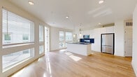 Located in Atlanta's vibrant West Midtown neighborhood, this well-appointed 2-bedroom, 2-bathroom residence offers a thoughtfully designed single-level layout. The open-concept living and kitchen area serves as the heart of the home, bathed in natural light from large windows and a glass door that leads to an outdoor balcony with open views of the surrounding treetops and Atlanta skyline. Light hardwood flooring flows seamlessly throughout the entire residence, enhancing the bright, airy ambiance.

The kitchen is a standout feature, anchored by a substantial island with a dark stone countertop and integrated sink, complemented by crisp white cabinetry extending to the ceiling, a bold navy blue subway tile backsplash, and a full suite of stainless steel appliances. Pendant lighting adds a modern, polished touch overhead.

Both bedrooms are generously proportioned, featuring large windows that invite natural light and outdoor views. The primary bedroom includes direct access to a well-sized closet with built-in wire shelving. Each bathroom is finished with clean, contemporary details — the primary bath showcasing a dual-sink vanity with dark stone countertops, black hardware accents, white cabinetry, and a glass-enclosed walk-in shower. The consistent use of light wood flooring, white walls, and black accent hardware creates a cohesive modern aesthetic throughout.