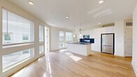 Located in Atlanta's vibrant West Midtown neighborhood, this well-appointed 2-bedroom, 2-bathroom residence offers a thoughtfully designed single-level layout. The open-concept living and kitchen area serves as the heart of the home, bathed in natural light from large windows and a glass door that leads to an outdoor balcony with open views of the surrounding treetops and Atlanta skyline. Light hardwood flooring flows seamlessly throughout the entire residence, enhancing the bright, airy ambiance.

The kitchen is a standout feature, anchored by a substantial island with a dark stone countertop and integrated sink, complemented by crisp white cabinetry extending to the ceiling, a bold navy blue subway tile backsplash, and a full suite of stainless steel appliances. Pendant lighting adds a modern, polished touch overhead.

Both bedrooms are generously proportioned, featuring large windows that invite natural light and outdoor views. The primary bedroom includes direct access to a well-sized closet with built-in wire shelving. Each bathroom is finished with clean, contemporary details — the primary bath showcasing a dual-sink vanity with dark stone countertops, black hardware accents, white cabinetry, and a glass-enclosed walk-in shower. The consistent use of light wood flooring, white walls, and black accent hardware creates a cohesive modern aesthetic throughout.