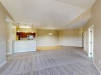 This well-appointed 2-bedroom, 2-bathroom residence in Sioux Falls, SD offers a thoughtfully designed single-floor layout with a warm, neutral color palette throughout. The open living area welcomes you with plush carpeting, vaulted ceilings, and a ceiling fan, flowing seamlessly into the kitchen and dining space. The kitchen is equipped with rich dark-wood cabinetry, stainless steel appliances including a refrigerator, range, and over-the-range microwave, and a convenient breakfast bar with light countertops. Light hardwood-style flooring runs through the kitchen and extends toward the dedicated laundry room, which includes an in-unit washer and dryer. The spacious primary bedroom features soaring vaulted ceilings, a ceiling fan, plush carpeting, and a large window that fills the room with natural light and outdoor views. The primary bathroom includes a vanity with dark wood cabinetry, a tub/shower combo, and tile flooring, with direct access to a generous walk-in closet with built-in shelving. The second bedroom also enjoys vaulted ceilings, a ceiling fan, and natural light. A second full bathroom mirrors the same clean, functional design. A sliding glass door from the living area opens to a private balcony, adding an inviting outdoor extension to the space.