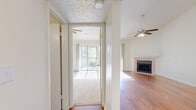 Located at 2335 W. Seminole Boulevard in Sanford, FL, this 760-square-foot single-floor unit offers 2 bedrooms and 2 bathrooms with a well-planned layout. The living room is a standout space, featuring soaring vaulted ceilings, a ceiling fan, gleaming hardwood floors, a tiled fireplace, and a sliding glass door that opens to a private balcony, flooding the room with natural light. The kitchen is efficiently designed with white cabinetry, dark countertops, stainless steel appliances including a dishwasher and range, a double sink, and a peninsula that connects seamlessly to the living area. Both bedrooms feature vaulted ceilings, ceiling fans, and plush carpeting. The primary bedroom measures 160 square feet and includes balcony access, while the second bedroom offers a closet. Each bathroom is appointed with white cabinetry, dark countertops, a large mirror, and a tub/shower combo with hardwood flooring. A dedicated laundry area houses a full-size washer and dryer. The unit's consistent use of vaulted ceilings throughout creates an airy, open ambiance that enhances the overall sense of space.
