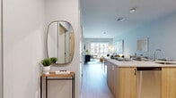 Located at 301 Winchester Ave in New Haven, CT, this well-appointed one-bedroom, one-bathroom residence offers a thoughtfully designed open-concept layout finished with light hardwood flooring and a neutral, contemporary palette throughout. The combined kitchen and living area serves as the heart of the home, where the kitchen features light wood cabinetry, stainless steel appliances including a full-size refrigerator, electric range, and over-the-range microwave, all complemented by clean white countertops. The living area is bathed in natural light from large windows that frame views of the surrounding neighborhood, creating a bright and welcoming atmosphere. The bedroom is a comfortable retreat, offering generous proportions, wide windows with abundant natural light, and a serene, airy ambiance with soft neutral tones. A dedicated walk-in closet with wire shelving and hanging rods provides practical storage. The full bathroom is finished with tile flooring, a wood-accented vanity with a white countertop, and a full tub-shower combination. The overall design of the residence is clean, modern, and functional, making it an inviting home in the heart of New Haven.