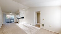 Located at 1248 SW Kiley Way in Beaverton, Oregon, this 2-bedroom, 1-bathroom single-floor home offers an efficient and comfortable layout. The open-concept living and dining area is a standout feature, highlighted by soaring vaulted ceilings that lend an airy, spacious feel well beyond the home's footprint. Neutral carpet, bright white walls, and abundant natural light from a sliding glass door create a warm, welcoming ambiance. The sliding door leads directly to a private balcony, offering a pleasant outdoor retreat with views of surrounding greenery.

The kitchen is positioned adjacent to the living area and features white cabinetry with light wood accents, black appliances including a range and refrigerator, a tile floor, and a pass-through breakfast bar that connects conveniently to the main living space. A dedicated laundry room houses a full-size washer and dryer alongside overhead cabinetry for additional storage.

The primary bedroom includes a mirrored sliding-door closet, a vanity with sink, and a window that brings in natural light. The second bedroom is a comfortable size with carpet flooring and a window overlooking the outdoors. The full bathroom features a tub/shower combination, tile flooring, and a granite-style countertop vanity. Three closets throughout the home provide ample storage.