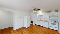 This efficient one-bedroom, one-bathroom unit in Cambridge, Maryland offers a thoughtfully organized layout across a single floor. Warm-toned hardwood flooring runs throughout the entire space, lending a cohesive and inviting feel to every room. The combined kitchen and living area serves as the heart of the home, featuring white cabinetry, a double-basin stainless steel sink, white appliances including a refrigerator and range, and a ceiling fan with light fixture. Large windows with blinds allow natural light to fill the open living space. The bedroom is a well-proportioned, private retreat with its own window offering natural light and outdoor views, a ceiling fan, and a built-in closet with bifold doors for convenient storage. The bathroom is clean and bright, finished in white with a vanity and mirror, toilet, and a tub/shower combination, with a window that adds natural ventilation and light. Additional spaces include an entrance area, a utility room, and a dedicated closet, maximizing functionality within the compact footprint. The consistent white walls and hardwood flooring throughout create a bright, clean aesthetic that makes the space feel open and easy to personalize.