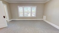 Unit 6 at 3845 Riveredge Rd is a 550-square-foot, single-floor apartment in Cleveland, OH, offering two bedrooms and one bathroom with a clean, modern aesthetic throughout. The spacious primary bedroom spans 220 square feet and features large triple windows that flood the room with natural light, crown molding, and neutral-toned carpet. The second bedroom also offers carpeted flooring, a closet, and a bright window. The kitchen is well-appointed with white shaker-style cabinetry, quartz countertops, a white subway tile backsplash, matte black hardware and fixtures, a stainless steel sink, dishwasher, and stainless steel appliances including a refrigerator, gas range, and microwave. Light hardwood-style flooring adds warmth to the kitchen area. The bathroom features a soaking tub with elegant large-format marble-look tile surround and matte black fixtures, lending a refined, contemporary feel. A connecting hallway provides practical flow between rooms, while the entry area includes crown molding and closet access. Neutral wall tones and consistent finishes create a cohesive ambiance throughout this efficient and stylish Cleveland apartment.