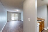 Located at 391 Old Griffin Rd in McDonough, GA, this one-bedroom, one-bathroom unit is thoughtfully laid out across a single floor. Wood-style flooring flows continuously throughout the space, complemented by soft gray walls and textured ceilings that lend a clean, cohesive aesthetic.

The combined living and dining area forms the heart of the unit, offering a generous, open feel with abundant natural light streaming through a set of double glass doors that lead directly to a private balcony — ideal for enjoying outdoor views.

The kitchen is positioned adjacent to the living area, separated by a structural column that provides a semi-open feel. It features warm wood-toned cabinetry, laminate countertops, a built-in sink, a dishwasher, and white appliances including a range and refrigerator.

The bedroom is a comfortable, well-proportioned room with a window that brings in natural light. It connects to a hallway that provides access to two closets, offering ample storage. A dedicated laundry area and utility room add practical convenience to the layout.

A full bathroom and a hallway complete the floorplan, making this a fully functional and efficiently designed single-level residence.