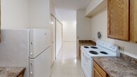 This two-bedroom, one-bathroom residence in Lexington, Kentucky offers a practical and efficient single-floor layout. The combined living and dining area serves as the heart of the home, featuring light-toned tile flooring that runs throughout the unit, neutral cream-colored walls, and a textured ceiling. A large window allows natural light to fill the space, creating a bright and open atmosphere.

The galley-style kitchen is well-equipped with warm oak cabinetry, dark laminate countertops, a white electric range, a refrigerator, and a dedicated sink area — providing ample storage and prep space in a compact, functional layout. The kitchen opens conveniently toward the hallway and main living areas.

Both bedrooms are comfortably sized with light tile flooring, neutral walls, and windows that invite natural light and outdoor views of the surrounding greenery. The primary bedroom offers a notably generous footprint. Notably, the unit features five closets distributed throughout, offering exceptional storage capacity for a residence of this size.

The full bathroom includes a shower/tub combination and tile flooring. A dedicated laundry area adds everyday convenience. The hallway connects all rooms efficiently, contributing to a cohesive and easy-to-navigate floor plan throughout this well-organized home.