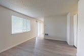 Located at 11412 NE 49th St in Vancouver, Washington, this single-floor, 3-bedroom, 2-bathroom home offers a practical and well-organized layout. The living room is a bright, open space featuring wood-look plank flooring, neutral-toned walls, a textured ceiling, and multiple windows with blinds that allow ample natural light. A sliding glass door provides additional light and outdoor access. The kitchen is outfitted with rich dark wood cabinetry, light countertops, and a full suite of stainless steel appliances, including a range, dishwasher, and range hood, all set over matching wood-look flooring. A central hallway connects the main living areas to the bedrooms and bathrooms, with flush ceiling lighting and a clean, neutral finish throughout. The bedrooms feature plush carpeting, windows with blinds, and built-in closets. The primary bedroom includes direct access to one of the two bathrooms. Each bathroom features a dark wood vanity with light countertops, a framed mirror, and wood-look flooring, maintaining a cohesive design aesthetic. The consistent use of neutral tones and complementary materials throughout the home creates a unified, move-in-ready atmosphere.