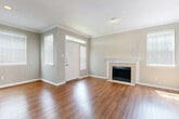 This single-story, 2-bedroom, 2-bathroom home offers a thoughtfully designed layout with a warm and neutral aesthetic throughout. The inviting living room serves as the heart of the home, featuring rich hardwood flooring, crown molding, and a classic tile-surround fireplace flanked by windows with plantation shutters that fill the space with natural light. A transom window above the front door adds an additional architectural touch.

The kitchen is well-equipped with white cabinetry, granite countertops, a diamond-pattern tile backsplash, and stainless steel appliances, including a range and over-the-range microwave. The hardwood flooring continues seamlessly from the living area into the kitchen.

Both bedrooms are carpeted and feature crown molding and ceiling fans. The generously sized primary bedroom includes a spacious walk-in closet outfitted with wire shelving on multiple levels, providing ample storage. The bathrooms are clean and functional, featuring granite-topped vanities and a tub-shower combination with hardwood flooring.

Two hallways connect the living spaces efficiently, and additional closets provide practical storage throughout. The home's consistent soft gray walls, white trim, and cohesive finishes create a bright, clean, and move-in-ready atmosphere.