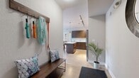 Located at 6655 Lookout Rd in Boulder, CO, this modern single-floor home offers a well-appointed layout with one bedroom, two full bathrooms, a dedicated office, and an open-concept kitchen and living area. The entryway welcomes you with soaring ceilings, light wood-look flooring, and a built-in mudroom bench with coat hooks. The kitchen is a standout, featuring rich dark-wood cabinetry, quartz countertops, stainless steel appliances, a central island with bar seating, and track lighting overhead. The living room is bathed in natural light from large sliding glass doors that open to a private outdoor patio. The bedroom is a tranquil retreat, highlighted by a striking reclaimed wood accent wall, soft carpeting, and bright clerestory windows. The dedicated office is generously sized with expansive windows offering outdoor views, ideal for productive work-from-home use. Both bathrooms are finished with dark wood vanities, quartz counters, and modern fixtures — one featuring a floating vanity design and the other a double-sink configuration. Neutral tones and clean lines throughout lend the home a cohesive, contemporary feel.