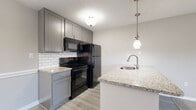Located at 11270 Fourth St N in Saint Petersburg, Florida, this single-floor residence offers a thoughtfully designed layout with modern finishes throughout. The open-concept living and dining area features a combination of durable wood-look flooring and plush carpeting, creating a warm and functional environment. Natural light flows in through large windows, with views of the surrounding exterior.

The kitchen is a standout feature, showcasing granite countertops, a peninsula with an undermount sink and pendant lighting overhead, and grey shaker-style cabinetry. A classic white subway tile backsplash complements the black appliances, which include a refrigerator, electric range, and built-in microwave. The space is further enhanced by a textured ceiling throughout.

The bedroom is generously sized with soft carpeting underfoot, a large window that invites natural light, and direct access to a walk-in closet. The bathroom is clean and functional, featuring a tiled tub/shower combo, wood-look flooring, grey vanity cabinetry, and granite countertops that mirror the kitchen's aesthetic. A hallway connects the main living areas to the private spaces, providing a well-organized and efficient floor plan suited for comfortable everyday living.