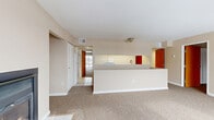 Located at 1700 Western Ave in Albany, NY, this two-story, 3-bedroom, 1-bathroom residence offers a well-organized layout spread across two floors. The main level opens into a generous living room highlighted by a dramatic floor-to-ceiling arched window wall with bold red framing, flooding the space with natural light and offering open views of the surrounding area. A fireplace adds warmth and character to the living area, which flows seamlessly into a kitchen featuring a raised breakfast bar peninsula and tile flooring. The upper level houses all three carpeted bedrooms, including a spacious primary bedroom with a private exterior door and access to natural light. The additional bedrooms are well-sized and share access to hallways with louvered closet doors. A full bathroom on the upper level features tile flooring, a vanity with granite-style countertop, and overhead lighting. A dedicated laundry room with a full-size washer and dryer adds everyday convenience. Throughout the home, neutral beige tones, carpeted living areas, and baseboard heating create a consistent and comfortable ambiance. A carpeted staircase connects both floors, completing this functional and light-filled multi-level residence.