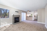 Located at 34050 Westchester Terr in Fremont, CA, this single-floor, 2-bedroom, 2-bathroom residence offers a practical and comfortable layout with thoughtful details throughout. The combined living and dining area serves as the heart of the home, featuring plush carpeting, a classic tile-surround fireplace with a white mantle, and a ceiling fan overhead. Natural light streams in through multiple windows with horizontal blinds, and a sliding glass door opens directly onto a private balcony. The kitchen is equipped with white cabinetry, grey quartz-style countertops, stainless steel appliances including a refrigerator and dishwasher, and durable wood-look flooring. The primary bedroom offers generous proportions, mirrored sliding closet doors, a ceiling fan with light fixture, and its own climate control. The second bedroom benefits from a large window with pleasant outdoor views and baseboard heating. Both bathrooms are functional and clean, with one featuring a full tub-shower combination. Additional highlights include five closets for abundant storage, a dedicated laundry area, and a utility room. A welcoming entrance and connecting hallway complete this well-organized, move-in-ready Fremont home.