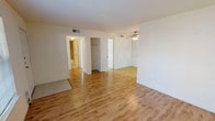 This single-floor 2-bedroom, 1-bathroom residence offers a thoughtfully designed layout that balances comfort and functionality. The main living area features warm hardwood-style flooring, neutral walls, and a ceiling fan with light fixture, creating a bright and welcoming atmosphere. A large window near the front entry allows abundant natural light to fill the space. The galley-style kitchen is efficiently arranged with white cabinetry, granite-look countertops, a double stainless steel sink, electric range, and built-in microwave — all finished with tile flooring that transitions seamlessly from the living areas. Both bedrooms are carpeted and generously sized, each equipped with ceiling fans and windows that bring in natural light. The primary bedroom includes two closets, providing ample storage. The full bathroom features tile flooring, a tub/shower combination with tiled surround accented by a decorative border, and a vanity with granite-look countertops. Closet space is well distributed throughout the unit, including a dedicated hallway closet. The clean, neutral palette and consistent finishes across the residence create a cohesive and move-in ready environment suitable for a variety of living arrangements.