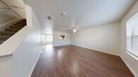 Located at 101 Tiffany Circle in Terrell, TX, this two-story home offers a practical and comfortable layout across two well-proportioned floors. The main level features an open-concept living, dining, and kitchen area bathed in natural light from well-placed windows. Rich, dark hardwood-style flooring flows throughout the main level, complemented by neutral white walls and a ceiling fan in the living room. A pass-through window connects the kitchen to the dining and living areas, creating an open, connected feel. The kitchen is equipped with warm, dark-toned wood cabinetry, white appliances including a dishwasher, range, and refrigerator, as well as a dedicated pantry for added storage. A laundry area and direct exterior access add everyday convenience to the main floor. The staircase leads to the upper level, where three bedrooms are situated, each featuring plush carpeting and individual closets with built-in shelving. The generously sized primary bedroom includes a walk-in closet. Both bathrooms are clean and functional, each featuring a full tub-shower combination. With five closets throughout and a thoughtful two-story layout, this home delivers efficient, comfortable living in a residential Terrell neighborhood.