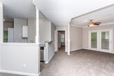 Located at 2010 Defoor Ave NW in Atlanta's West Midtown neighborhood, this single-level residence offers a well-organized floor plan with distinct living, dining, kitchen, and bedroom areas. The living room is a standout space, featuring a tray ceiling accented with crown molding, a ceiling fan, and plush carpeting. French doors allow natural light to filter in and provide outdoor access. A decorative column separates the living area from the dining space, which is distinguished by its own tray ceiling and pendant lighting.

The kitchen is efficiently designed with white cabinetry, granite-style countertops, a subway tile backsplash, and a full suite of stainless steel appliances including a refrigerator, range, and over-the-range microwave. Wood-look flooring adds a clean, modern touch to this space.

The bedrooms are carpeted and well-proportioned, each equipped with ceiling fans and ample natural light. One bedroom features a distinctive octagonal window, while another includes a walk-in closet. Both bathrooms include wood-look flooring, white vanities, and tub-shower combinations with a classic black-and-white checkered tile accent border.
