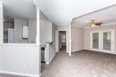 Located at 2010 Defoor Ave NW in Atlanta's West Midtown neighborhood, this single-level residence offers a well-organized floor plan with distinct living, dining, kitchen, and bedroom areas. The living room is a standout space, featuring a tray ceiling accented with crown molding, a ceiling fan, and plush carpeting. French doors allow natural light to filter in and provide outdoor access. A decorative column separates the living area from the dining space, which is distinguished by its own tray ceiling and pendant lighting.

The kitchen is efficiently designed with white cabinetry, granite-style countertops, a subway tile backsplash, and a full suite of stainless steel appliances including a refrigerator, range, and over-the-range microwave. Wood-look flooring adds a clean, modern touch to this space.

The bedrooms are carpeted and well-proportioned, each equipped with ceiling fans and ample natural light. One bedroom features a distinctive octagonal window, while another includes a walk-in closet. Both bathrooms include wood-look flooring, white vanities, and tub-shower combinations with a classic black-and-white checkered tile accent border.
