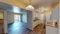 This single-floor residence offers a practical and well-organized layout designed for comfortable everyday living. The open-concept living and dining area is finished with durable wood-style flooring that extends throughout the main living spaces, creating a cohesive and easy-to-maintain environment. Natural light pours in through large sliding glass doors that lead to a private outdoor patio, offering a pleasant connection to the outdoors.

The kitchen is efficiently designed with white cabinetry, laminate countertops, and a full suite of white appliances including a gas range, built-in microwave, refrigerator, and dishwasher. A pendant light fixture and track lighting illuminate the space, while a pass-through opening connects the kitchen to the living area, enhancing the open feel. A dedicated laundry area is conveniently tucked just off the kitchen.

The bedroom is a comfortable, carpeted retreat featuring a ceiling fan with integrated lighting and a window that brings in natural light. The full bathroom includes a soaking tub and shower combination with white and gray tile surround, wood-style flooring, and a vanity with countertop storage. Clean, neutral wall tones throughout the residence provide a versatile backdrop suitable for a variety of interior styles.