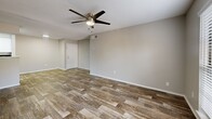 Located at 3101 Grand Pavilion Drive in Tampa, FL, this single-floor residence offers three bedrooms, two bathrooms, and a thoughtfully arranged layout. Rich wood-style flooring runs throughout the home, complemented by neutral gray walls and textured ceilings, creating a consistent and clean aesthetic across every room.

The open-concept living, dining, and kitchen area forms the heart of the home. The kitchen features white shaker cabinetry, light quartz-style countertops, a peninsula with a range hood overhead, stainless steel appliances, and a skylight that enhances natural brightness. The living and dining areas are generously proportioned, with ceiling fans and windows fitted with blinds allowing for natural light and airflow.

Each of the three bedrooms includes a ceiling fan, window with blinds, and wood-style flooring. The primary bedroom offers a comfortable footprint with direct closet access. The additional bedrooms are well-sized, with one featuring a louvered bi-fold closet. A total of three closets provides ample storage throughout.

Both bathrooms are finished with white tile tub-shower combinations, light countertops, white cabinetry, and matching wood-style flooring. A utility room and a private balcony round out the functional features of this well-appointed Tampa residence.