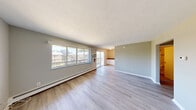 This 2-bedroom, 1-bathroom single-floor unit offers a practical and comfortable layout designed for efficient living. The combined kitchen and living room area serves as the heart of the home, featuring light hardwood-style flooring, neutral gray walls, and large windows that flood the space with natural light. A sliding glass door opens to a private balcony, extending the living area outdoors and providing pleasant exterior views. Baseboard heating runs throughout the main living area, ensuring year-round comfort.

The kitchen is well-appointed with white cabinetry, dark laminate countertops, and a full suite of appliances including a range, microwave, and dishwasher, all arranged in a convenient U-shaped configuration that maximizes workspace.

Both bedrooms are finished with soft carpeting and neutral-toned walls. The primary bedroom is generously sized, offering a walk-in closet and a window overlooking greenery. The second bedroom is a comfortable, quiet space with carpet flooring. A connecting hallway links the bedrooms to the full bathroom, which features a clean white tub-shower combination with chrome fixtures.

The unit also includes a dedicated hallway entry and benefits from a cohesive, move-in-ready aesthetic throughout.