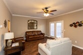Located in Knoxville, Tennessee, this two-story home offers a thoughtfully designed layout across two levels. The main floor features a welcoming living room with rich hardwood flooring, crown molding, a ceiling fan, and a decorative arched mirror that adds character to the space. French doors invite natural light and provide outdoor access. Adjacent to the living room, the dining area is finished with the same warm hardwood floors and accented by an elegant pendant chandelier, making it an ideal space for entertaining. The kitchen is well-equipped with ample light maple cabinetry, striking dark granite-style countertops, a double sink, track lighting, and tile flooring, providing generous storage and workspace. A half bath on the main floor features tile flooring and crown molding. The upper level hosts multiple bedrooms, each with plush carpet and natural light from windows. The primary bedroom includes a ceiling fan and a dresser area. Additional bedrooms are cozy and well-sized, each with closet access. A full bathroom serves the upper level, showcasing warm wood cabinetry, dark granite countertops, a large mirror with vanity lighting, and tile flooring. Throughout the home, neutral tones and classic finishes create a cohesive, inviting atmosphere.