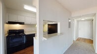 Located at 6615 The Lakes Dr in Raleigh, NC, this single-floor residence offers a practical and well-organized layout designed for comfortable everyday living. The kitchen is a standout functional space, featuring white cabinetry, light-toned countertops, hardwood flooring, and black appliances including a full-size refrigerator, electric range, and dishwasher. A double-basin sink sits beneath under-cabinet lighting, maximizing utility. A defining architectural feature is the pass-through window with a granite-style ledge that connects the kitchen to the adjacent living area, creating an open and communicative flow between the two spaces. The living area is generously proportioned, finished with wall-to-wall carpet, and opens directly to a private balcony through large sliding glass doors dressed with sheer vertical blinds, allowing abundant natural light to fill the room. The bedroom is a spacious, quiet retreat with soft carpet and neutral wall tones. The bathroom features classic white fixtures, a tub-shower combination with tiled surround, a wall mirror, and rich hardwood flooring that complements the clean, simple aesthetic. Throughout the residence, a neutral color palette and clean lines contribute to a bright, airy ambiance.