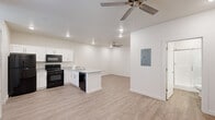 Located at 1800 Frontier Rd in Barling, Arkansas, this efficiently designed single-floor unit offers a thoughtfully organized layout across a compact footprint. The open-concept kitchen and living area serves as the heart of the space, featuring light-toned luxury vinyl plank flooring that runs throughout, crisp white shaker-style cabinetry, and granite-look countertops. A full suite of black appliances—including a refrigerator, electric range, over-the-range microwave, and dishwasher—provides complete functionality. Recessed lighting and dual ceiling fans keep the space bright and well-ventilated, while a wall-mounted mini-split HVAC unit ensures year-round comfort. A window with blinds allows natural light to filter into the living area, which also features a dedicated electrical panel for convenience. The bathroom is cleanly finished with white shaker cabinetry, granite-look countertops, wood-look flooring, and a walk-in shower enclosed by sleek sliding glass doors. A dedicated closet offers practical storage. The overall aesthetic is clean and modern, with a neutral white and beige palette that lends the space a bright, move-in-ready feel throughout.