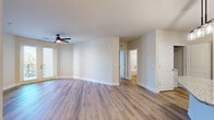 This thoughtfully designed 2-bedroom, 2-bathroom residence offers a comfortable and modern living experience across a single floor. The open-concept kitchen and living area serves as the heart of the home, featuring warm wood-look luxury vinyl plank flooring and a ceiling fan. The kitchen is outfitted with crisp white shaker cabinets, granite countertops, a center island, and a full suite of stainless steel appliances, including a refrigerator, range, and microwave. The living room extends naturally from the kitchen and opens to a private balcony through elegant French doors, filling the space with natural light and outdoor views. The primary bedroom is a generously sized retreat finished with soft carpet, a ceiling fan, and direct access to a dedicated en-suite bathroom and a walk-in closet with built-in wire shelving. The en-suite bath features white shaker vanity cabinetry, granite countertops, a large mirror, and a glass-enclosed walk-in shower. The second bedroom also offers carpeted flooring, a ceiling fan, and windows with natural light. The second full bathroom mirrors the same refined aesthetic with matching granite countertops and a shower-tub combination, maintaining a consistent and polished design throughout the entire residence.