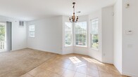 Located at 601 Dover Chase Blvd in Toms River, NJ, this well-appointed 2-bedroom, 2-bathroom home offers a comfortable and functional single-floor layout. The dining area is a standout space, featuring a charming chandelier, large bay windows with views of surrounding greenery, and a combination of tile and carpet flooring that transitions seamlessly into the living areas. The kitchen is equipped with warm honey-toned cabinetry, granite-style countertops, and a full suite of appliances including a refrigerator, electric range, and built-in microwave. A conveniently positioned laundry area is accessible directly from the kitchen. Both bathrooms are finished with light ceramic tile flooring and feature wood-toned vanities topped with granite-style countertops; one includes a full soaking tub. The two bedrooms are carpeted and bright, with the primary bedroom offering a generous footprint and a large bay window arrangement that floods the room with natural light and frames outdoor greenery. Two closets provide ample storage throughout. The attached garage includes an automatic opener and a utility area housing the water heater, offering additional functional space. The home's clean white walls and natural light create a bright, inviting ambiance throughout.