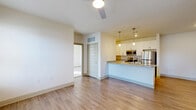 Located at 5871 BroadAcre in McCordsville, Indiana, this single-floor residence offers a thoughtfully designed 2-bedroom, 2-bathroom layout with a clean, modern aesthetic throughout. The open-concept living area seamlessly integrates the living room, dining space, and kitchen, all finished with warm wood-look flooring and crisp white walls. The kitchen is a standout feature, anchored by a granite-topped island with a built-in sink, pendant lighting overhead, white cabinetry, and a full suite of stainless steel appliances including a refrigerator, range, and microwave. A pantry provides additional storage convenience. The living area is accented by a ceiling fan and flows naturally toward the bedrooms. Both bedrooms feature plush carpeting and generous closet space, including a spacious walk-in closet with wire shelving. The two bathrooms are well-appointed with granite vanity countertops, white cabinetry, and combination tub-shower units with brushed nickel fixtures. A dedicated laundry room with side-by-side washer and dryer adds everyday convenience. The overall ambiance is bright, clean, and move-in ready, reflecting a contemporary residential design suited for comfortable living.
