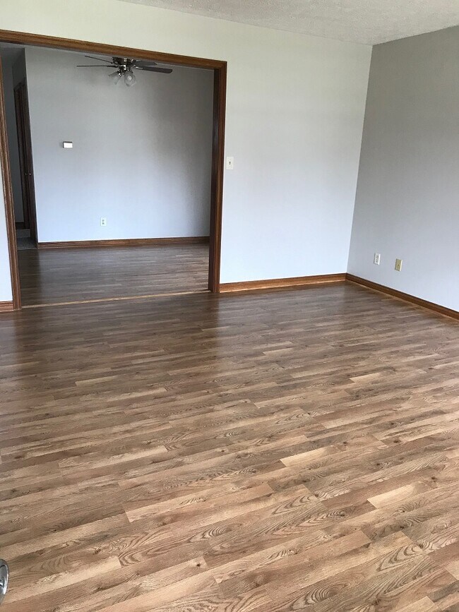 living room looking into dining room showing new laminate flooring - 11218 Township Line Rd