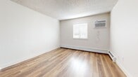 This well-appointed one-bedroom, one-bathroom unit in Thornton, Colorado offers a thoughtful layout across a single floor, making efficient use of its space. The living area features warm hardwood-style flooring, neutral walls, and a textured ceiling, creating a clean and inviting atmosphere. A wall-mounted air conditioning unit and baseboard heating ensure year-round comfort, while a window allows natural light to brighten the room.

The kitchen is a functional galley-style space outfitted with light wood cabinetry, gray countertops, and a full suite of stainless steel appliances including a refrigerator, range, microwave, and dishwasher. Hardwood-style flooring continues throughout, and additional windows bring in ample natural light.

The bedroom is a comfortable, well-sized retreat featuring plush carpeting, a ceiling fan with integrated light, a wall-mounted air conditioning unit, and baseboard heating. A dedicated closet adds practical storage to the room.

The bathroom is clean and bright, featuring hardwood-style flooring, a vanity with gray countertop and light wood cabinetry, and a full bathtub and shower combination. A window provides natural ventilation and light.

A hallway connects the rooms, with carpeted flooring completing the transition between spaces. This unit offers a cohesive, move-in ready living experience in a convenient Thornton location.