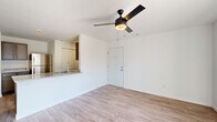 This single-floor, 3-bedroom, 2-bathroom home in Lafayette, Indiana offers a well-organized layout with a clean, modern aesthetic. The living room is bright and open, featuring light wood-look flooring, crisp white walls, a ceiling fan with integrated lighting, and a sliding glass door that opens to a private balcony with views of the surrounding neighborhood. The kitchen is efficiently designed with dark cabinetry, granite-style countertops, stainless steel appliances including a refrigerator and range, and recessed lighting. A breakfast bar connects the kitchen to the living area, creating a seamless flow for everyday living and entertaining. The three bedrooms offer comfortable accommodations, with the primary bedroom providing generous space and its own ceiling fan. Bedroom flooring transitions to plush carpet, adding warmth and comfort. The two bathrooms are finished in a simple, clean style, each featuring a full tub-shower combination with white surrounds, hardwood-look flooring, and gray vanity cabinetry. A carpeted hallway connects the bedrooms and bathrooms, providing a natural separation between living and sleeping areas. Throughout the home, consistent white walls and neutral finishes create a cohesive, move-in-ready environment.