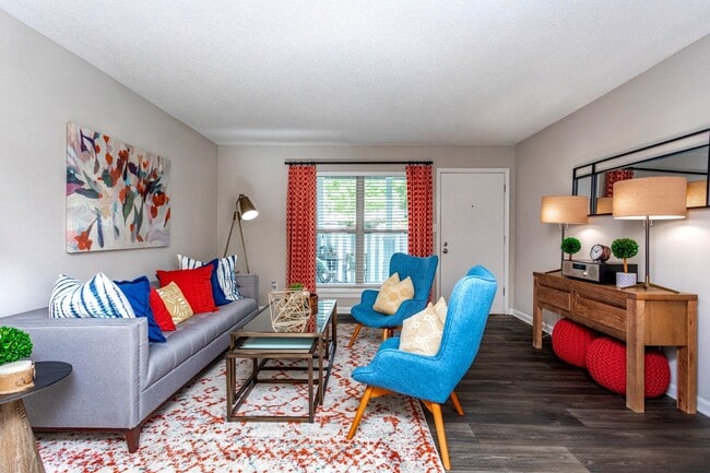 Spacious living room with modern furnishings and natural light. - Domain Apartments