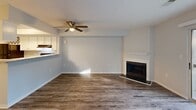 Located at 1 Milligan Ln in Johnson City, TN, this two-story home offers a practical and well-appointed layout across two floors. The main level features a bright, open living and dining area with durable wood-look flooring, a ceiling fan, and a classic fireplace with a white mantel as a focal point. Large sliding glass doors flood the space with natural light and provide access to a private patio with pleasant outdoor views. The adjacent kitchen is well-equipped with white cabinetry, granite-style countertops, stainless steel appliances including a refrigerator, and a pass-through bar connecting to the dining area. A convenient laundry area and a half bathroom complete the lower level. Upstairs, the primary bedroom offers comfortable carpeting, multiple closets, and a window for natural light. The second bedroom is equally well-sized with soft carpet and ample closet space. Both bathrooms are finished with granite-style vanity countertops and wood-look flooring; the full bathroom includes a tub-shower combination. Throughout the home, neutral tones, textured ceilings, and clean finishes create a cohesive and move-in ready atmosphere.
