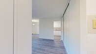 Located at 1875 Steeles Ave W in Toronto, this 2-bedroom, 1-bathroom unit offers a practical and well-organized layout across a single floor. Light wood laminate flooring runs throughout, lending a clean and cohesive look to the space.

The kitchen features white cabinetry, beige countertops, a built-in sink, and white appliances including a refrigerator and electric range. It opens directly toward the dining area, which is illuminated by a pendant light fixture and a window with natural light.

The living room is bright and open, with large windows that frame views of mature trees and the surrounding neighbourhood. A sliding door provides access to a private balcony, where residents can enjoy outdoor views of green trees and the landscaped grounds below.

Both bedrooms are well-proportioned, with the primary bedroom offering a comfortable amount of space. Each room features large windows that allow natural light to filter in, along with baseboard heating units.

The bathroom is finished with beige wall tiles and includes a full soaker tub with a handheld showerhead. A dedicated hallway and closet provide additional storage and organization. Overall, the unit presents a clean, functional living environment in a convenient Toronto location.