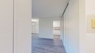 Located at 1875 Steeles Ave W in Toronto, this 2-bedroom, 1-bathroom unit offers a practical and well-organized layout across a single floor. Light wood laminate flooring runs throughout, lending a clean and cohesive look to the space.

The kitchen features white cabinetry, beige countertops, a built-in sink, and white appliances including a refrigerator and electric range. It opens directly toward the dining area, which is illuminated by a pendant light fixture and a window with natural light.

The living room is bright and open, with large windows that frame views of mature trees and the surrounding neighbourhood. A sliding door provides access to a private balcony, where residents can enjoy outdoor views of green trees and the landscaped grounds below.

Both bedrooms are well-proportioned, with the primary bedroom offering a comfortable amount of space. Each room features large windows that allow natural light to filter in, along with baseboard heating units.

The bathroom is finished with beige wall tiles and includes a full soaker tub with a handheld showerhead. A dedicated hallway and closet provide additional storage and organization. Overall, the unit presents a clean, functional living environment in a convenient Toronto location.