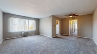 Located at 14246 Cedar Rd in University Heights, Ohio, this single-floor unit offers a practical and well-organized layout designed for comfortable everyday living. The spacious living room serves as the heart of the unit, featuring plush gray carpeting, neutral-toned walls, and a large window dressed with vertical blinds that allows generous natural light to fill the space. A wall-mounted air conditioning unit provides climate control, while an overhead ceiling fan with a built-in light fixture adds functionality. The open sightline connecting the living area to the rest of the unit creates an airy, cohesive feel throughout.

The kitchen is efficiently laid out with warm wood cabinetry, dark countertops, wood-look vinyl flooring, and a window above the sink that brings in additional natural light. White appliances, including a range and refrigerator, complete the setup.

The bedrooms are carpeted and feature neutral walls, with each room offering closet space fitted with hanging rods. One bedroom includes a ceiling fan, while another benefits from a large window with outdoor views.

The bathroom is cleanly finished with white subway tile surrounding the full-size soaking tub, a white vanity with under-cabinet storage, a mirrored medicine cabinet, and wood-look flooring for a cohesive, updated appearance.