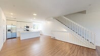 Located in Palmetto Bay, FL, this well-appointed three-story home offers four bedrooms and four bathrooms across three thoughtfully designed floors. The ground level houses a garage with an automatic opener, a utility area, and an entrance that leads into the main living spaces above.

The primary living floor showcases a bright, open-concept layout combining the living room, dining area, and kitchen. Warm wood-look flooring flows throughout, complemented by clean white walls and recessed lighting. The kitchen is a standout feature, boasting white shaker cabinetry, stainless steel appliances, a large center island with a white quartz countertop and sink, and a window that fills the space with natural light. A pantry and laundry area add everyday convenience. A crisp white staircase with spindle railings connects all three levels seamlessly.

The upper floors host all four bedrooms, each accompanied by its own bathroom and closet. The primary bedroom features a tray ceiling with a ceiling fan, hardwood-style flooring, a walk-in closet, and a private en-suite bath with large-format tile and a glass-enclosed shower. A balcony provides an outdoor retreat. Hallways are finished with neutral tile flooring, and the overall aesthetic throughout is clean, modern, and move-in ready.