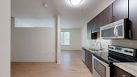 Located at 8250 Westpark Drive in McLean, Virginia, Unit 344 is a well-designed studio that makes efficient use of its single-floor layout. The open-plan kitchen and living area form the heart of the unit, offering a clean, modern aesthetic defined by light hardwood flooring and bright white walls. The kitchen is thoughtfully appointed with rich dark-espresso cabinetry, granite-style countertops, a tiled backsplash, and a full suite of stainless steel appliances including a refrigerator, electric range, built-in microwave, and dishwasher. A large window in the living area invites generous natural light and frames views of the surrounding tree canopy, lending a tranquil, green outlook to the space. The open layout provides flexibility for arranging a living and sleeping area within the same footprint. The bathroom features warm-toned tile flooring, a combined tub and shower with white subway tile surround, a toilet, and a vanity with a granite-topped cabinet in a matching espresso finish. The unit's neutral color palette, consistent flooring, and modern finishes create a cohesive, move-in-ready environment suited for those seeking a functional and stylish residence in the McLean area.