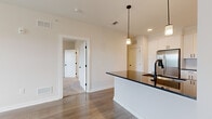 Located at 1500 Bell Road in Nashville, TN, this well-appointed one-bedroom, one-bathroom unit offers a thoughtfully designed single-floor layout with modern finishes throughout. The open-concept living and kitchen area serves as the heart of the home, featuring warm hardwood-style flooring, recessed lighting, and a peninsula with a striking dark countertop that flows into a full kitchen. The kitchen is equipped with white shaker-style cabinetry, stainless steel appliances including a French door refrigerator, electric range, and built-in microwave, complemented by a subway tile backsplash and elegant pendant lighting. The spacious bedroom is carpeted for comfort, bathed in natural light from a large window with outdoor views, and includes a ceiling fan. A dedicated closet and hallway provide added storage and privacy. The bathroom features large-format tile flooring, a white vanity with dark granite countertop, matte black fixtures, and a tiled tub-shower combination. Neutral tones and clean lines throughout the unit create a bright, contemporary ambiance well-suited for modern living in Nashville.