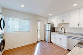 Located at 3106 Memorial Dr SE in Atlanta's 30317 zip code, this 2-bedroom, 2-bathroom single-floor home offers a clean, modern aesthetic with thoughtful finishes throughout. Light wood-look flooring runs continuously across the living room, bedrooms, hallway, and kitchen, creating a cohesive and inviting atmosphere. The bright living room features recessed flush-mount lighting and direct access to the entry door, keeping the layout open and functional. The kitchen is well-appointed with white shaker cabinetry, granite-look countertops, black hardware accents, and a full suite of stainless steel appliances including a refrigerator, range, microwave, and dishwasher. A stacked washer and dryer unit is conveniently integrated into the kitchen area alongside an exterior door, adding practical utility. Both bedrooms are well-proportioned, bathed in natural light from blinded windows, and fitted with ceiling fans. The primary bedroom includes an ensuite bathroom. The bathrooms are finished with neutral tile flooring, granite countertops, white subway tile surrounds with a sage green accent band, and matte black fixtures. Two closets provide ample storage. The overall ambiance is bright, clean, and move-in ready.