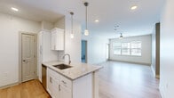 Located at 6386 Transit Rd in Depew, NY, this well-appointed 2-bedroom, 2-bathroom unit offers a thoughtfully designed single-floor layout with modern finishes throughout. The open-concept kitchen and living area serves as the heart of the home, anchored by a granite-topped island with a stainless steel undermount sink and elegant pendant lighting. White shaker cabinetry, a classic subway tile backsplash, and stainless steel appliances—including a refrigerator, range, and microwave—complete the kitchen. Light hardwood flooring flows seamlessly through the main living areas, while a ceiling fan and generous windows fill the living room with natural light. The spacious primary bedroom offers comfortable proportions with plush carpeting and ample natural light. The second bedroom mirrors this cozy aesthetic, also featuring carpet flooring and a bright window. Both bathrooms are finished with granite-topped vanities and white cabinetry; one includes a glass-door walk-in shower, while the other features a full tub-shower combination. Two dedicated closets provide convenient storage. The overall ambiance is clean, bright, and contemporary, making this a polished and functional living space.