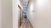 Located on the 6th floor of 305 Michigan Ave in the heart of downtown Detroit, this efficiently designed unit offers a well-organized layout across a single floor. The entry hallway sets a modern tone with wood-look flooring, exposed black metal track lighting overhead, and built-in wall hooks for coats and accessories — a practical yet stylish introduction to the space.

The open living and dining area doubles as a bedroom, maximizing every square foot. A bold, textured feature wall provides a striking focal point, while large windows fitted with roller shades frame panoramic views of the Detroit skyline, allowing natural light to fill the room. Exposed industrial-style ceiling rails add an urban loft character throughout.

The kitchen is fully equipped with stainless steel appliances — including a refrigerator, range, microwave, and dishwasher — set against crisp white cabinetry and light countertops. The tall ceilings in this area enhance the sense of openness.

The bathroom is clean and functional, featuring a single-sink vanity with a large mirror, wood-look tile flooring, and white fixtures. Two closets provide ample storage for a space of this scale.

This unit delivers a modern urban living experience in a prime downtown Detroit location.