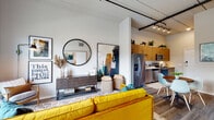 Located at 301 Second St S in Winter Haven, Florida, this single-story residence showcases a contemporary design defined by soaring ceilings, light wood-tone finishes, and an open, airy atmosphere throughout. The ceilings feature exposed industrial-style elements, including track lighting and visible ductwork, lending the space a distinctly urban character.

The kitchen is thoughtfully designed with light wood cabinetry extending to ceiling height, white subway tile backsplash, quartz countertops, and a full suite of stainless steel appliances including a refrigerator, dishwasher, microwave, and range. It flows seamlessly into the open living area, which is anchored by sliding glass doors that open to a private patio, filling the space with abundant natural light and outdoor views.

The bedrooms are calm and well-proportioned, each featuring windows that invite natural light and views of surrounding greenery. The bathroom offers a clean, modern aesthetic with a frameless sliding glass shower enclosure, white tile surround, and wood-toned vanity cabinetry. Light wood-style flooring extends throughout the unit, tying each space together in a cohesive, contemporary aesthetic.