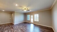 Located at 4575 North Major Drive in Beaumont, Texas, this single-story, 4-bedroom, 2-bathroom home offers a well-designed layout across a comfortable footprint. Rich, dark hardwood-style flooring flows throughout the main living areas, complemented by neutral-toned walls and crisp white trim that create a clean, cohesive aesthetic. Crown molding adds a refined architectural detail to the living room and primary spaces, while ceiling fans with integrated lighting provide both comfort and function.

The living room is bright and inviting, featuring a glass door and flanking windows that allow generous natural light and provide views of the open landscape beyond. The kitchen stands out with dark espresso cabinetry, granite countertops, a subway tile backsplash, stainless steel appliances, and a large island. An adjacent walk-in pantry adds practical storage.

The primary bedroom is generously sized, featuring its own ceiling fan and natural light. A spacious walk-in closet with built-in shelving and dual hanging rods offers excellent organization. The bathrooms are finished with granite-topped dark vanities, framed mirrors, and tiled shower surrounds. Additional bedrooms are well-proportioned with ample natural light. A dedicated laundry room and multiple closets round out the functional layout. A covered back porch offers peaceful views of open green space.