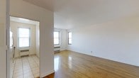 Located at 112 Hoyt St in Stamford, Connecticut, this one-bedroom, one-bathroom unit offers a straightforward and functional layout across a single floor. The living area is bright and open, featuring warm hardwood flooring that extends throughout the main space, contributing to a clean and inviting atmosphere. White walls and smooth ceilings enhance the sense of light and openness, while dual windows allow natural light to fill the room and provide views of the surrounding neighborhood. A baseboard radiator beneath the windows ensures comfortable heating throughout the seasons. The entryway transitions from light-toned tile flooring, offering a practical and distinct separation from the main living area. The overall design is simple and neutral, providing a versatile canvas well-suited for a range of interior styles. The unit's understated aesthetic and efficient use of space make it a practical residence in the Stamford area, with easy access to the amenities and conveniences of the surrounding community.