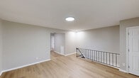 Located at 319 Columbia Ave in Stratford, NJ, this thoughtfully updated one-bedroom, one-bathroom unit offers a clean, modern aesthetic across a single floor. Light wood laminate flooring runs throughout, complementing the neutral gray walls and crisp white trim to create a bright, cohesive atmosphere.

The open living area is accessed via a staircase with a black metal railing and features recessed and flush-mount ceiling lighting. The space flows naturally toward the kitchen, which has been fully renovated with white shaker-style cabinetry, white quartz countertops, a classic subway tile backsplash, a stainless steel sink, and stainless steel appliances including a range, over-the-range microwave, and refrigerator.

The bedroom is generously sized, offering a wall-mounted air conditioning unit, a baseboard heating system, a window with natural light, and a sliding double-door closet for ample storage. The neutral tones and clean lines maintain the unit's modern character throughout.

The bathroom features a full soaking tub with a tiled surround in large-format gray stone tile, complemented by matte black fixtures including a showerhead and faucet set, adding a contemporary touch to the space.